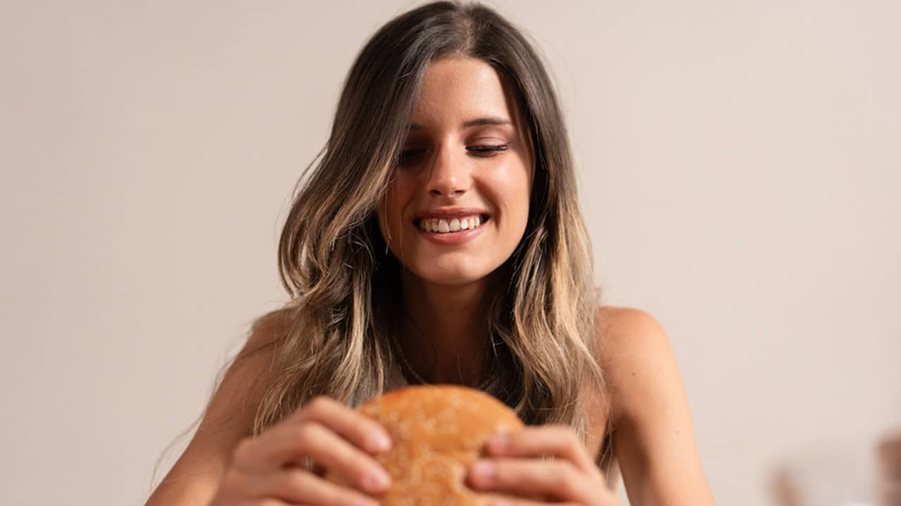 Mindful Eating for Weight Loss: How to Transform Your Relationship with Food happy woman eating a burger