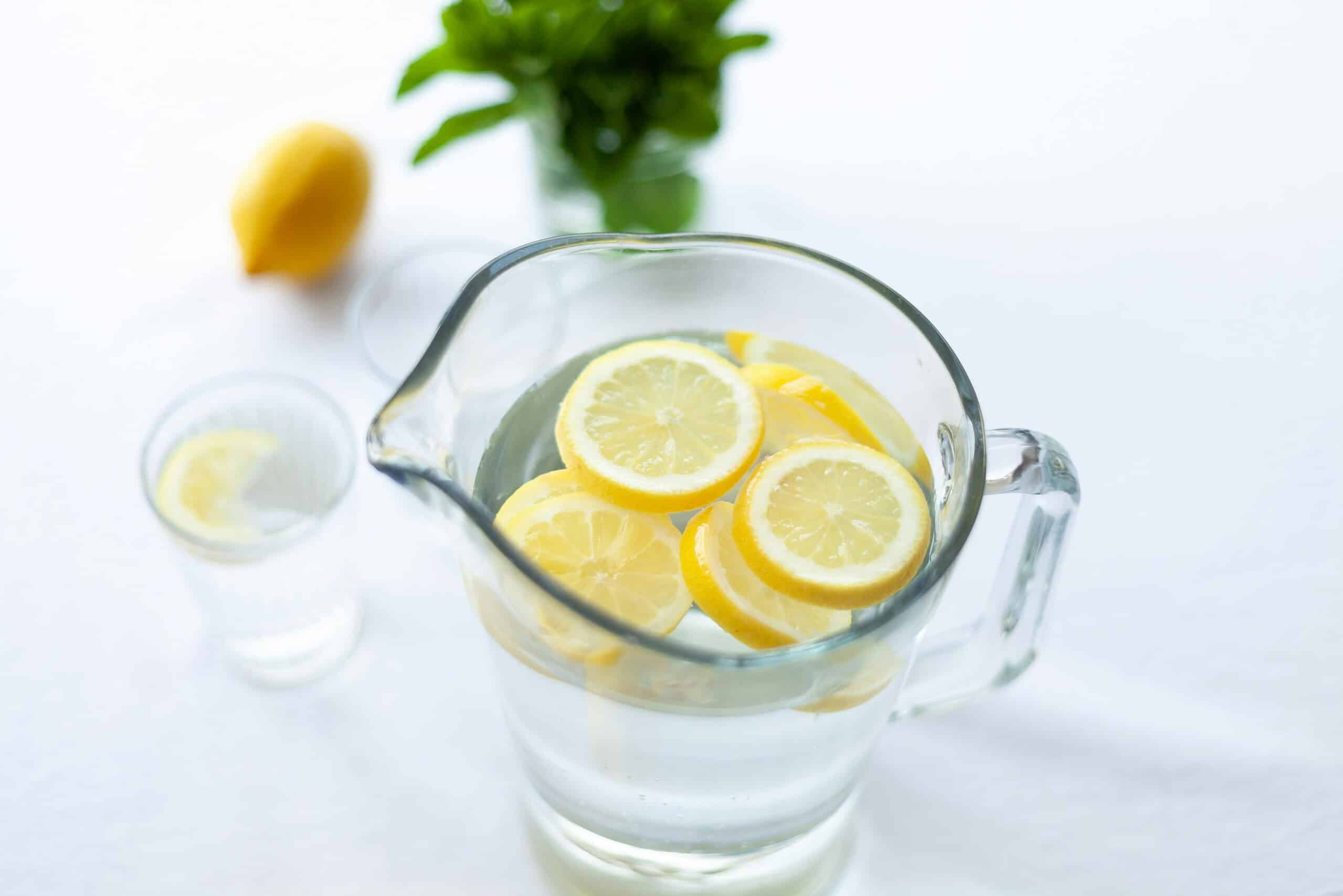 Clean lemon water in glass pitcher, supporting hydration, wellness, and natural health.
