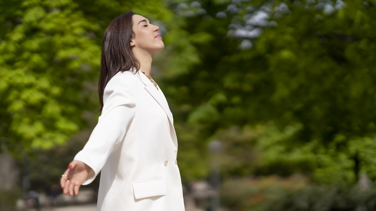 Side view of a relaxed woman breathing fresh air outdoors in a green park