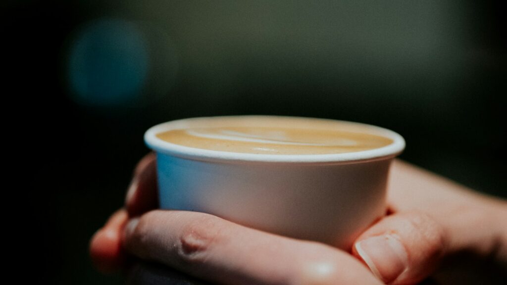 Hands holding a warm latte for a calm morning ritual with Everyday Dose mushroom coffee by Josh Trent Wellness and Wisdom
