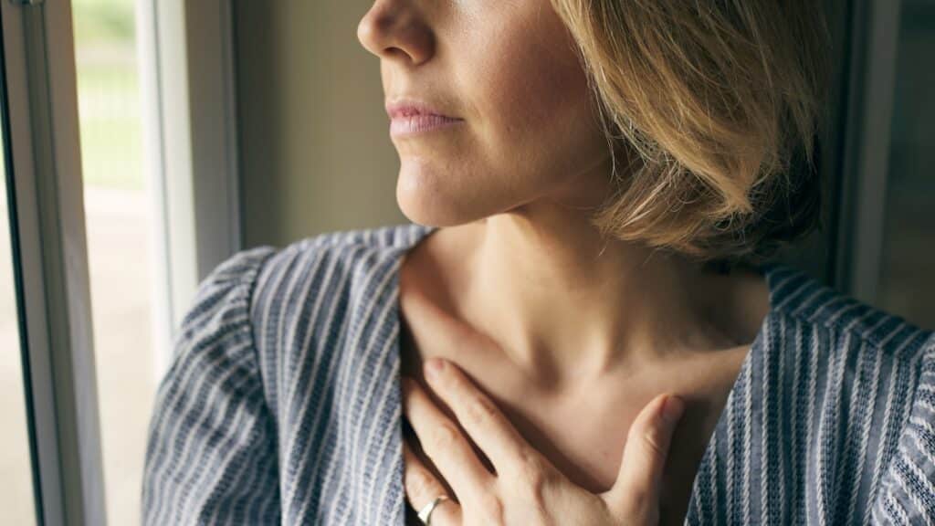A person stretching gently in soft morning light with a hand over their heart representing how to honor your body by Josh Trent Wellness and Wisdom