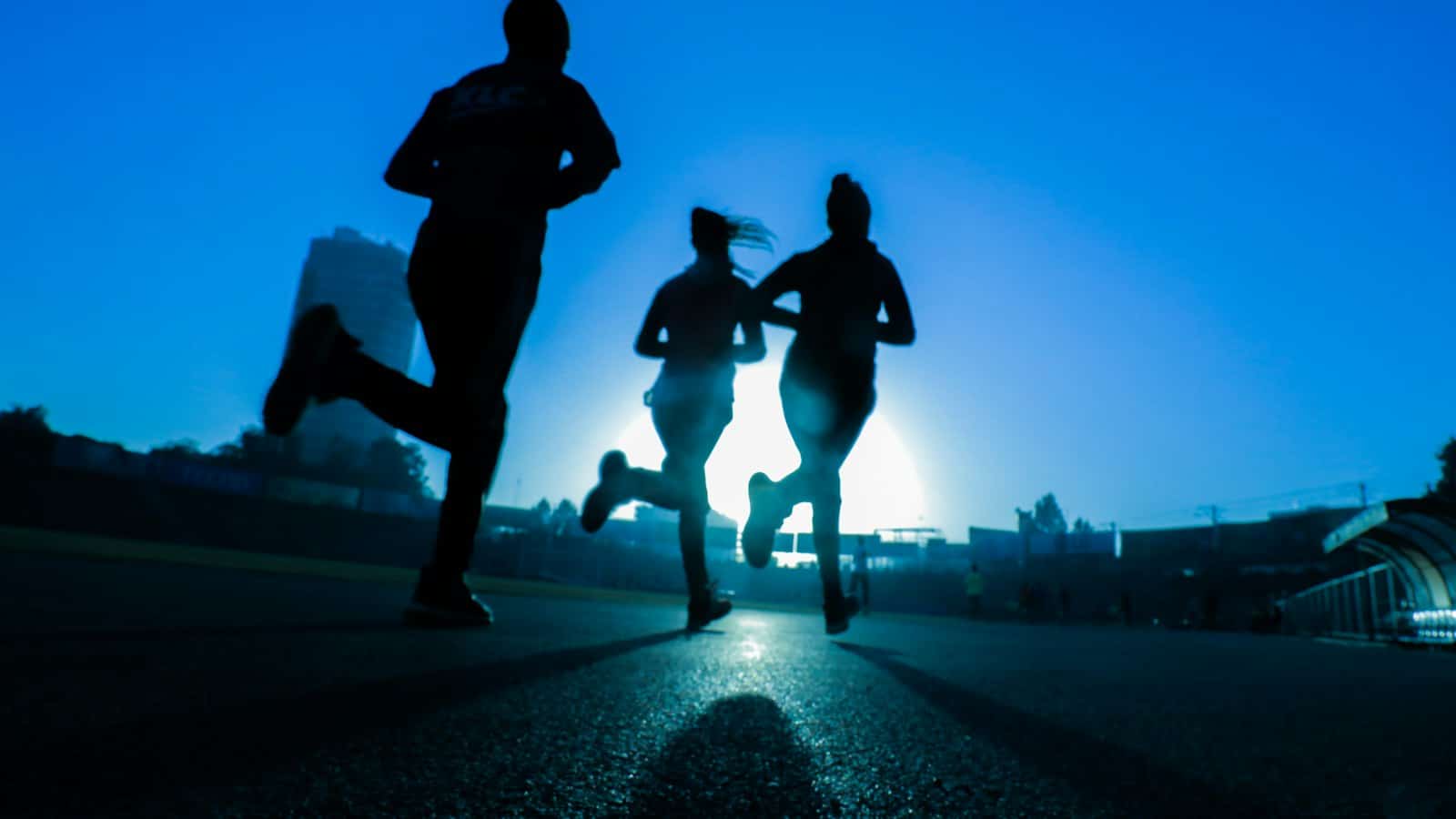 Three runners silhouetted against a bright morning sky, an energizing image for how to find motivation by Josh Trent Wellness and Wisdom